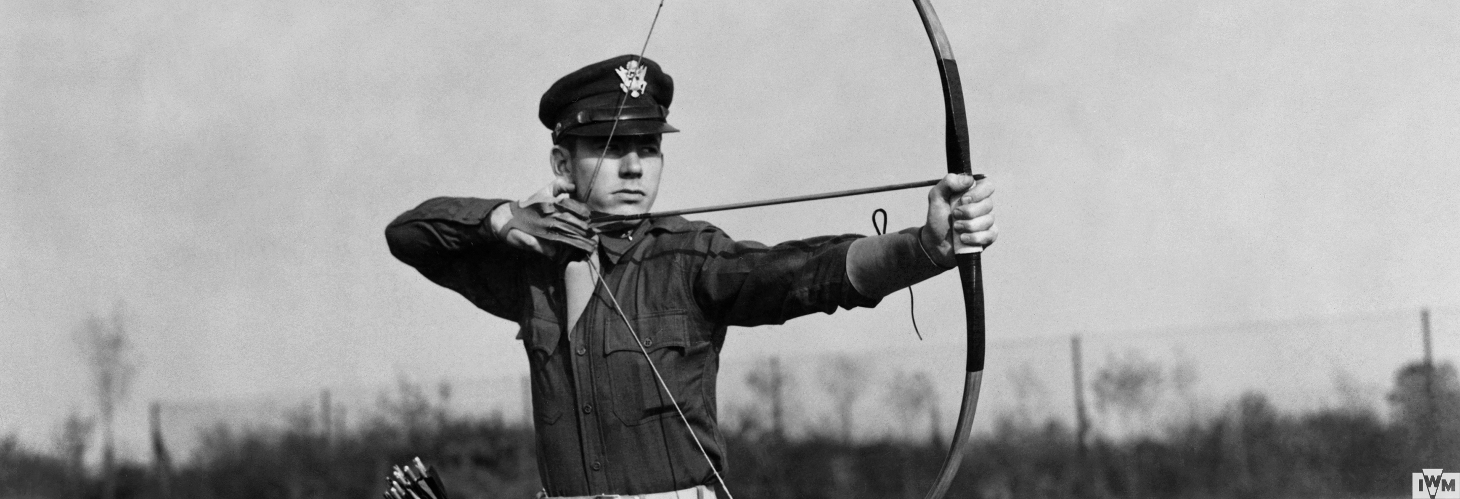 Capt Edwin Caudill of the 4th Fighter Group, the Station Adjuntant practises with his bow and arrow with which he has shot several rabbits and partridges