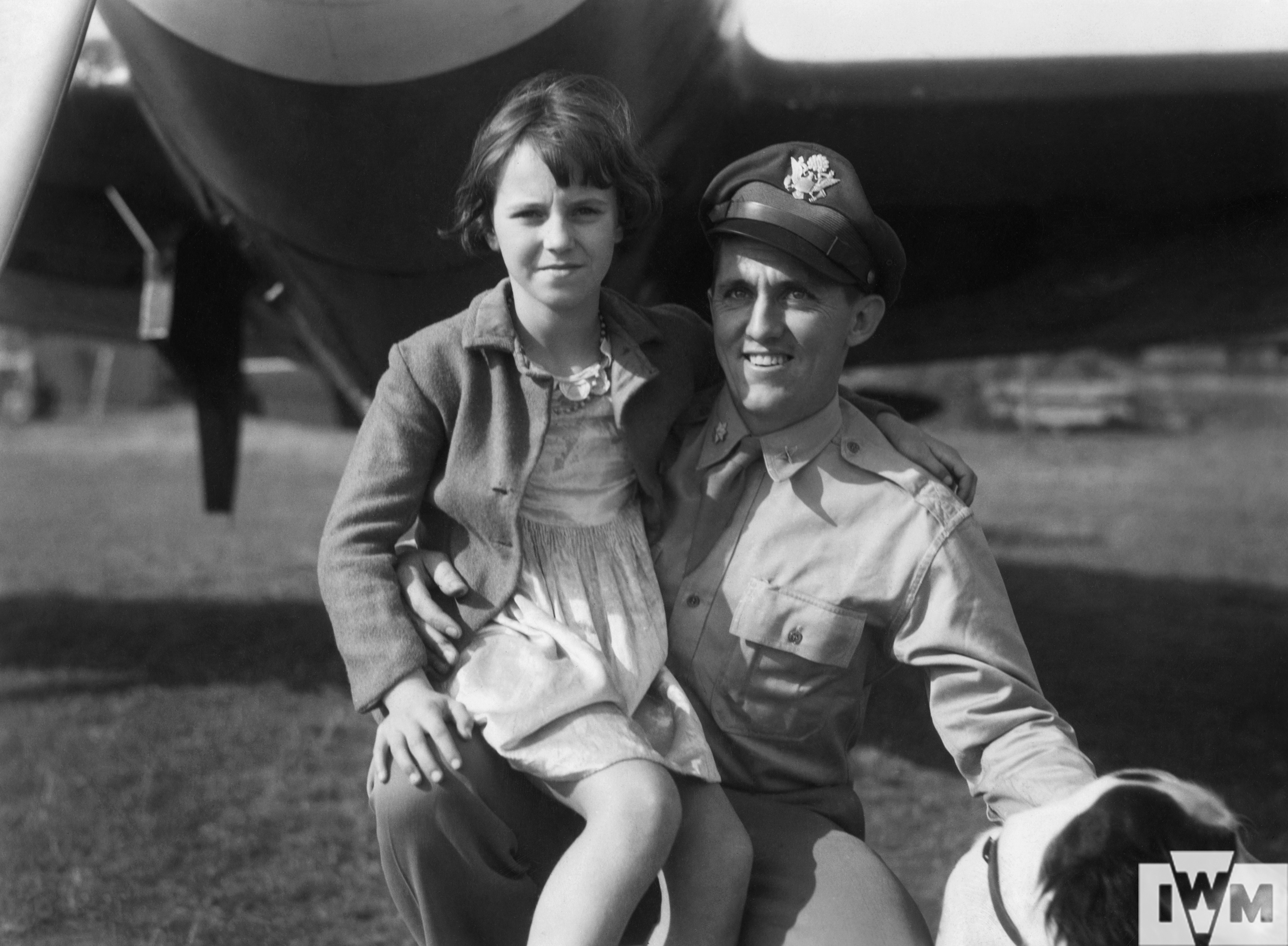 Major Jesse C Davis of the 78th Fighter Group, with a local young girl on his knee, at Duxford.