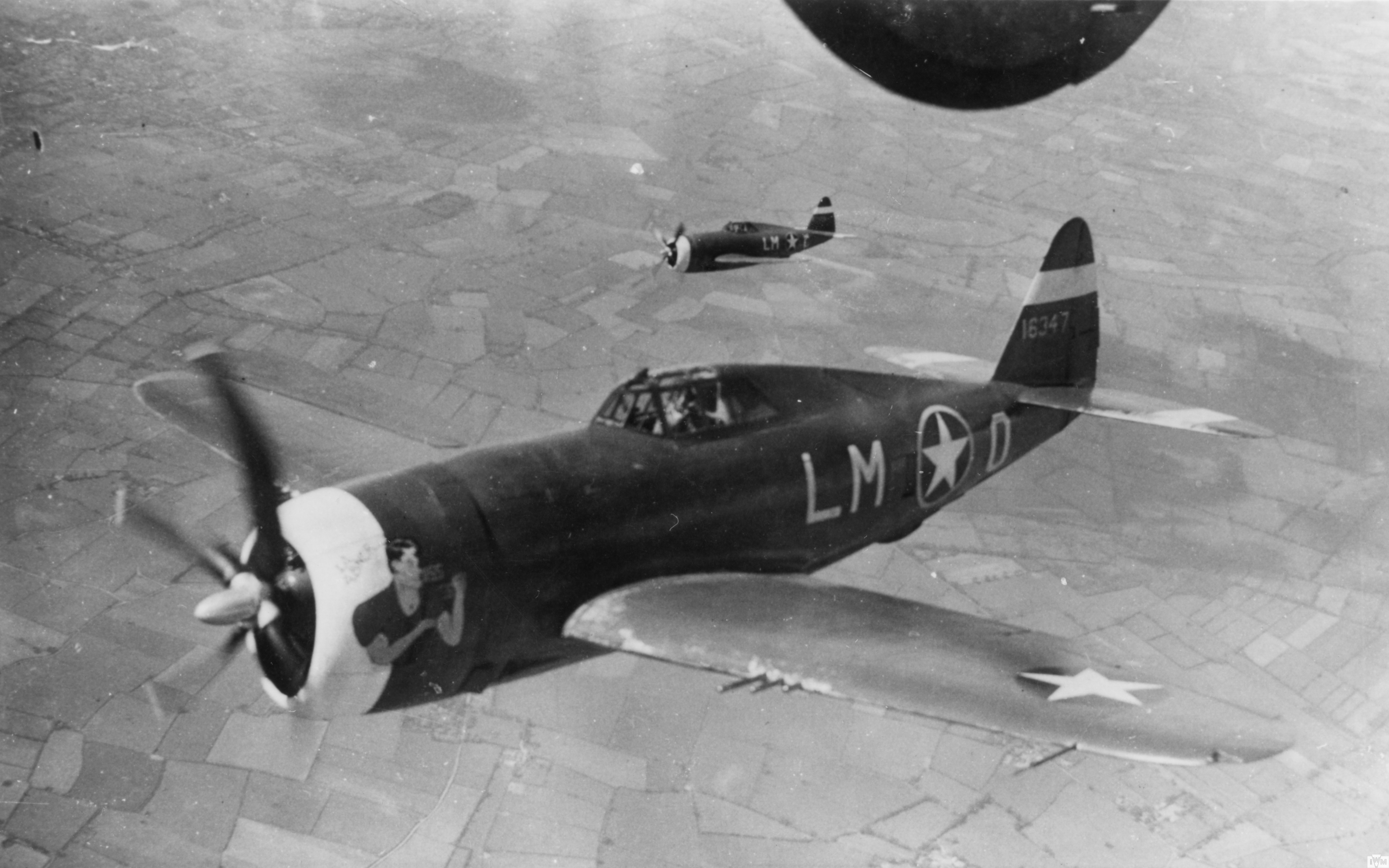 P-47 Thunderbolts of the 56th Fighter Group escort a B-24 Liberator.