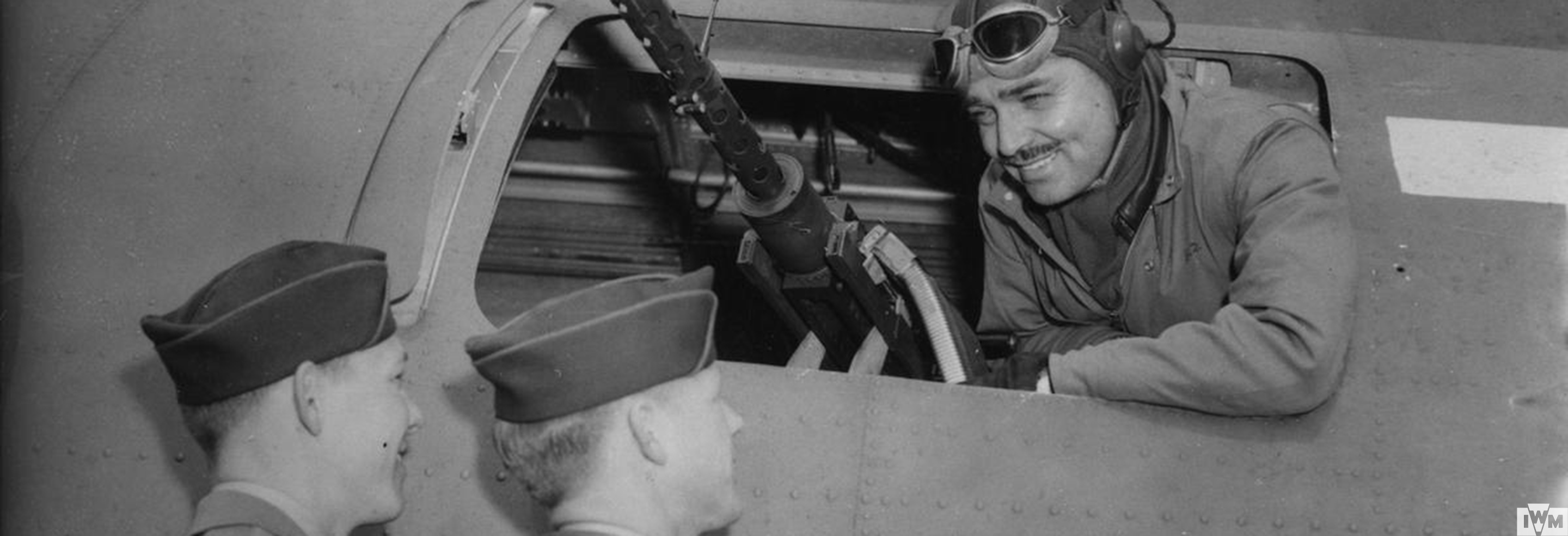 Hollywood actor Clark Gable, talks to  Sergeant Phil Hulse and Sergeant Kenneth Huls of the 351st Bomb Group from the waist gun position of a B-17 Flying Fortress.
