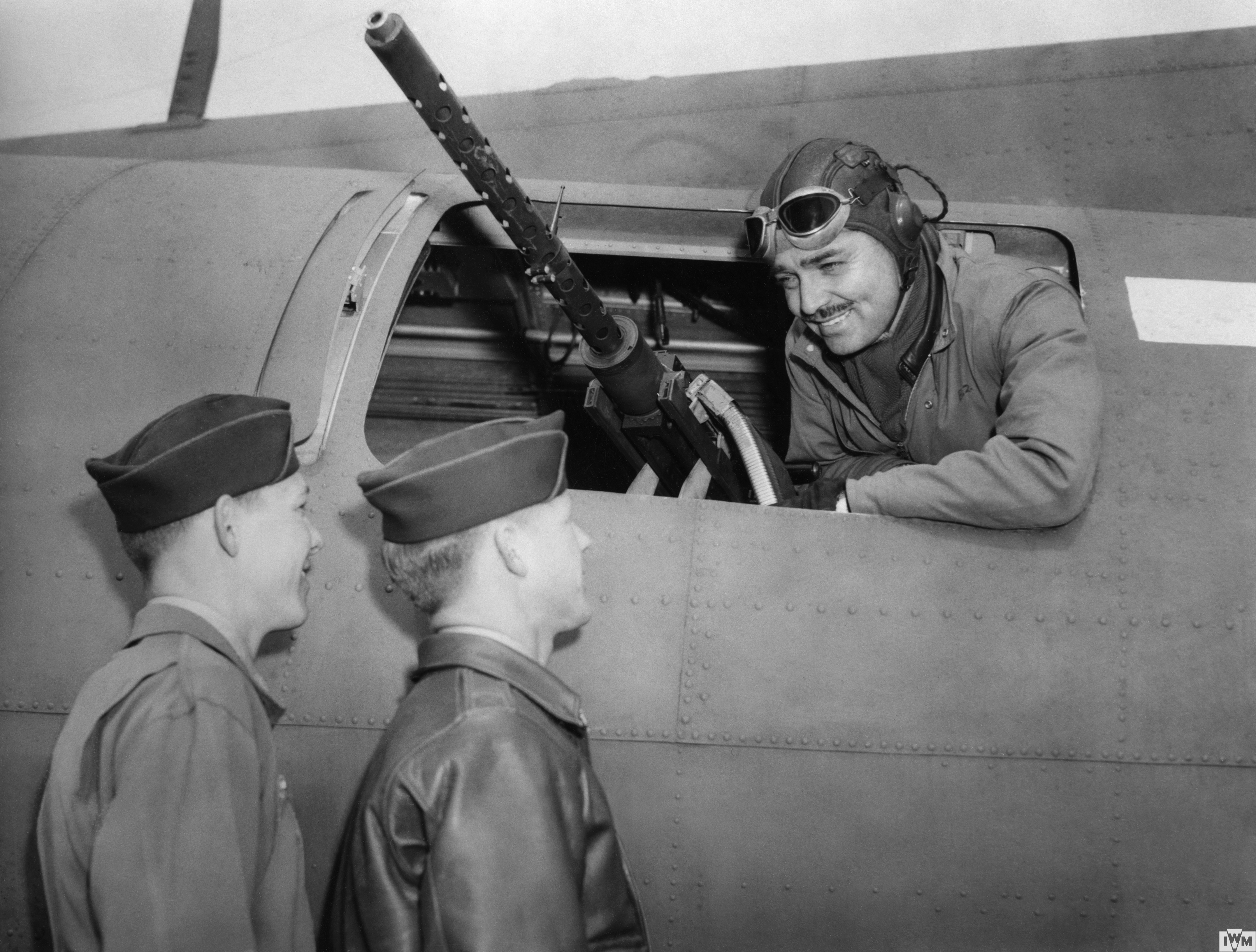 Hollywood actor Clark Gable, talks to  Sergeant Phil Hulse and Sergeant Kenneth Huls of the 351st Bomb Group from the waist gun position of a B-17 Flying Fortress.