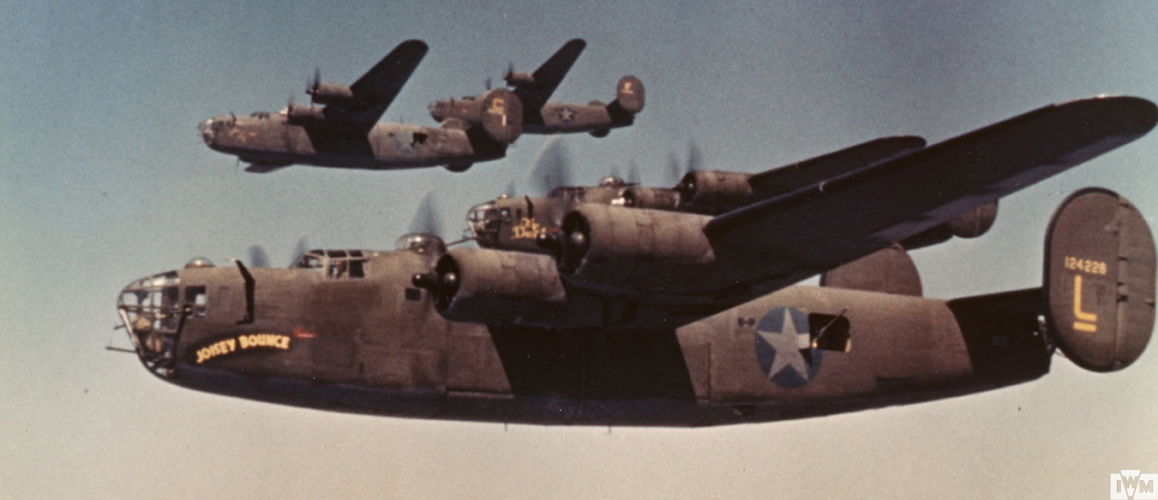 B-24 Liberators, including (serial number 41-24226 ) nicknamed "Joisey Bounce" of the 93rd Bomb Group fly in formation during a mission.