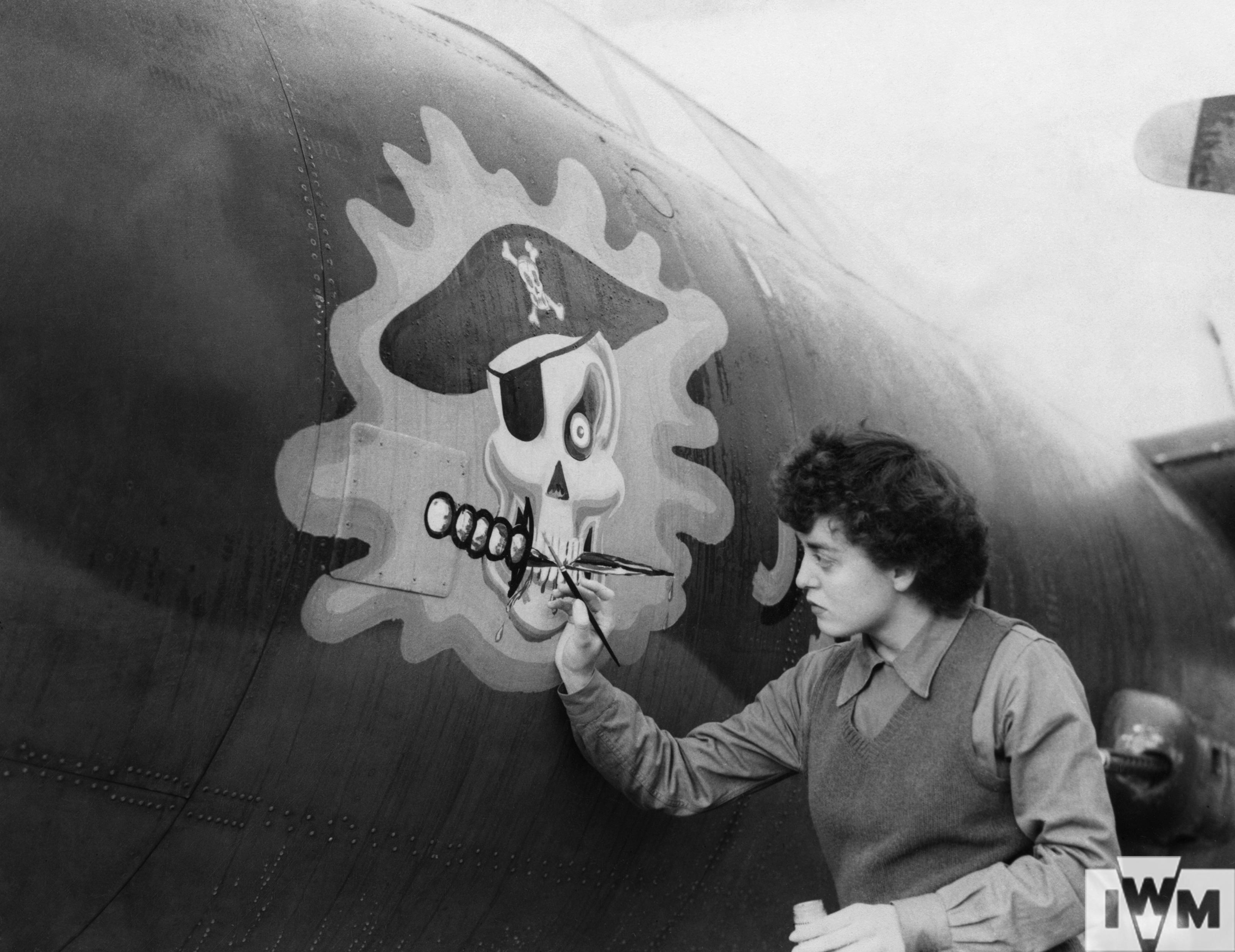 Private First Class Barbara O'Brien of the Women's Army Corps, paints the nose of a B-26 Marauder nicknamed "Jolly Roger" of the 323rd Bomb Group