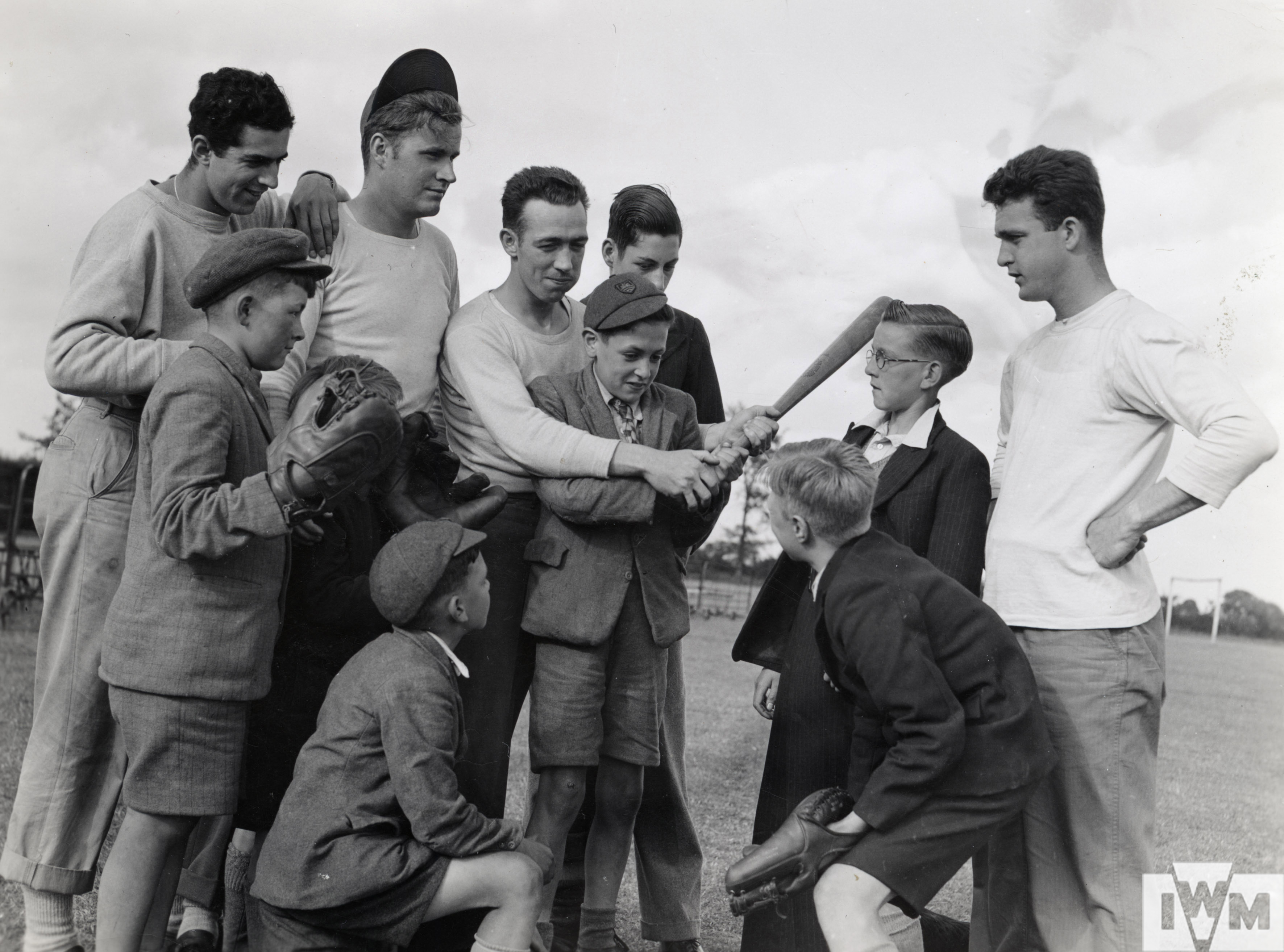English boys visting an 8th Air Force base are given an introduction to baseball by USAAF personnel.