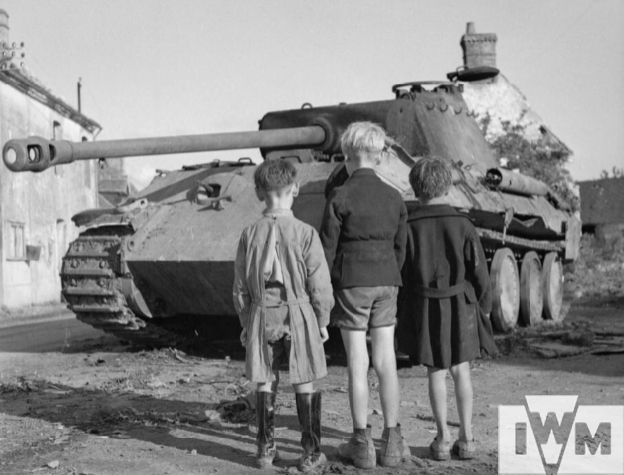 Three French boys looking at a knocked-out German Panther tank in the Falaise pocket, 25 August 1944.