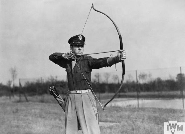Capt Edwin Caudill of the 4th Fighter Group the Station Adjuntant practises with his bow and arrow with which he has shot several rabbits and partridges