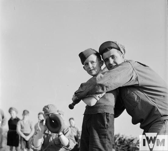 A USAAF airman shows a British boy how to swing a baseball bat